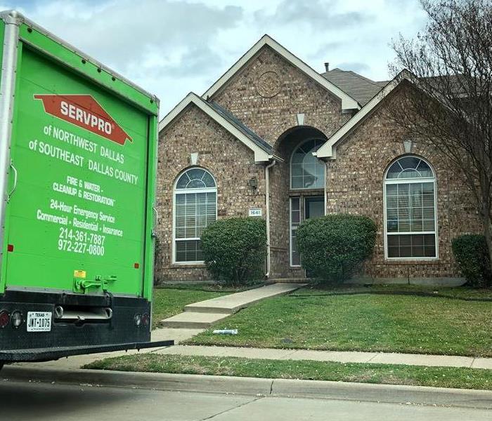 The front of a home, with a SERVPRO truck parked on the road. 