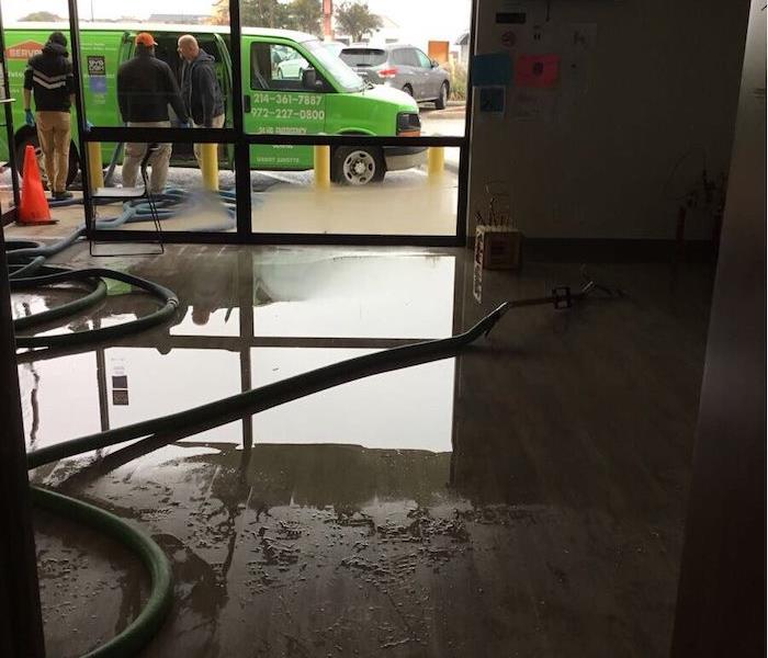 Water on floor, SERVPRO vehicle parked outside