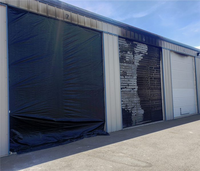 a tarp covering the door of a fire damaged storage facility