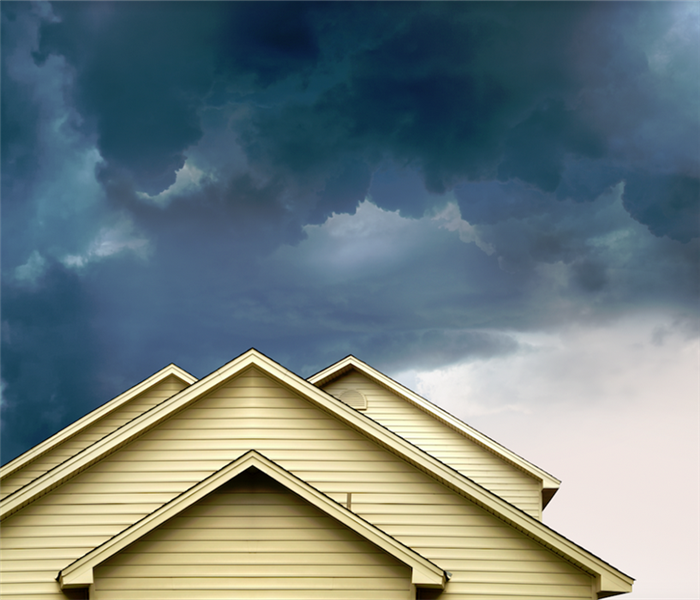 a dangerous storm brewing over top of a house